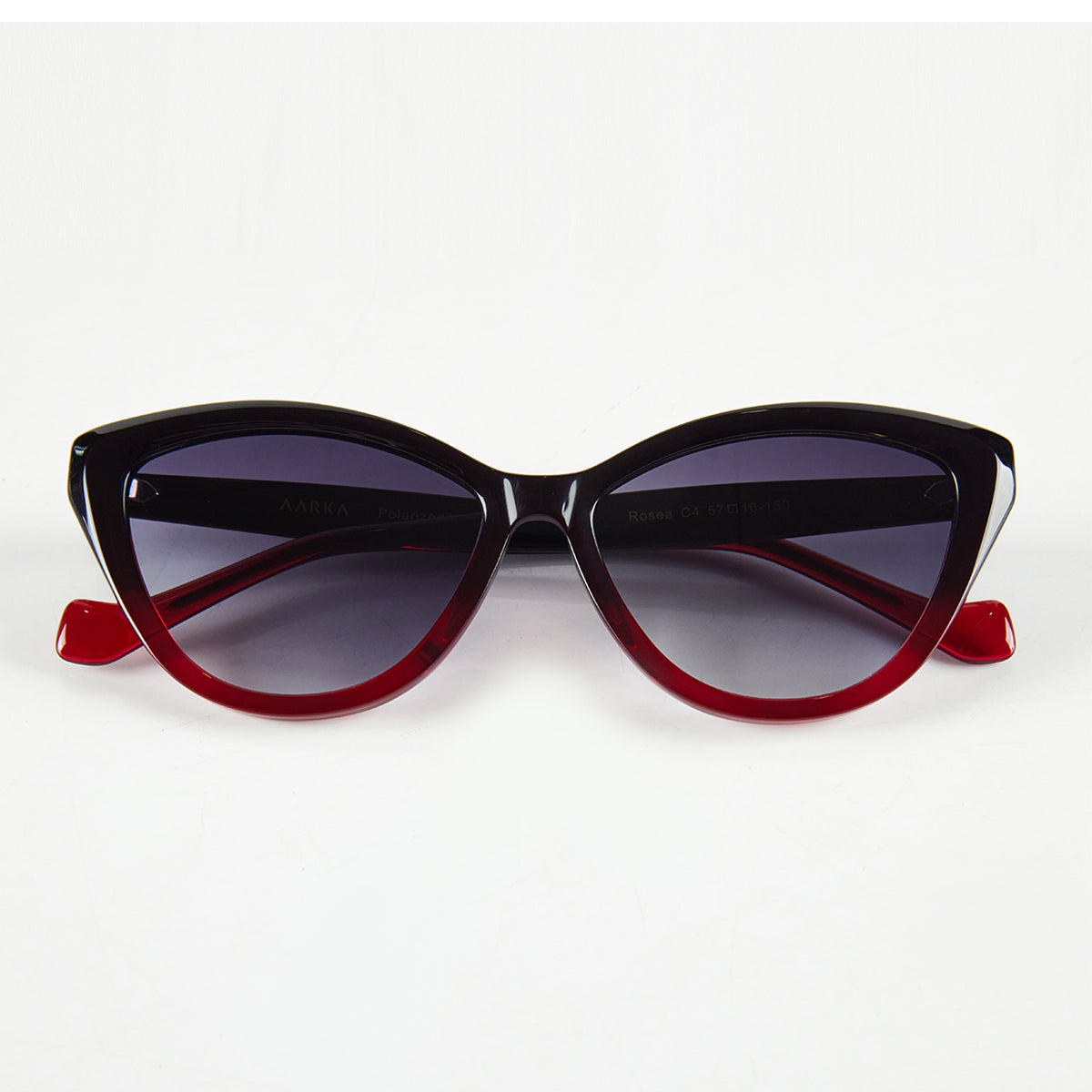 Folded view of Aarka Rosea designer cat-eye sunglasses with black and red frame and polarized lenses.